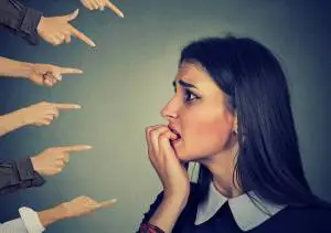 Concerned women being pointed at by multiple hansds.